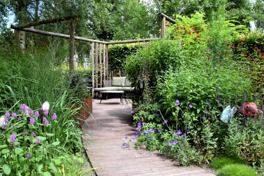 Sfeervolle achtertuin met uitbundige beplanting Dutch Quality Gardens